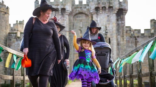 Family in fancy dress for October half-term, with Bodiam Castle in the background